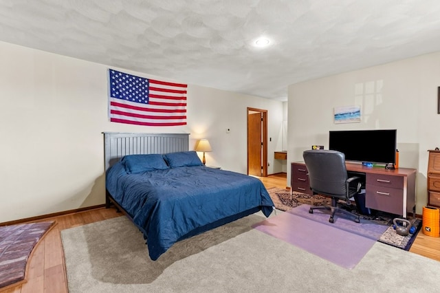 bedroom featuring baseboards and wood finished floors