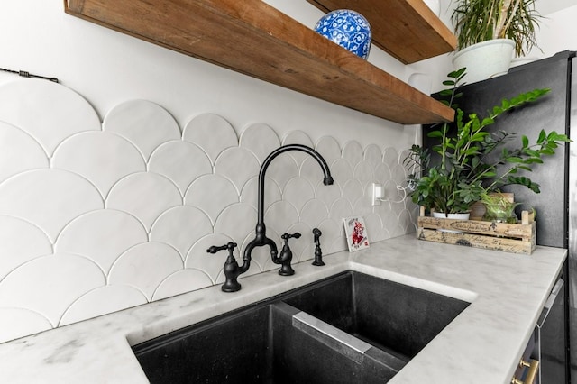interior details with a sink, light countertops, open shelves, and backsplash