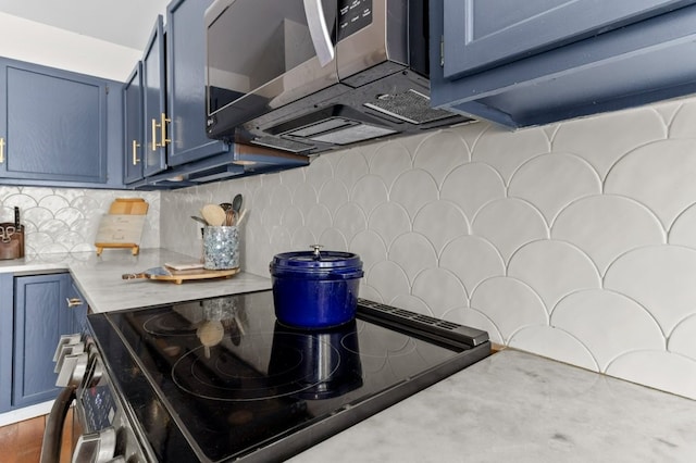 kitchen with stainless steel microwave, light countertops, blue cabinetry, and electric stove