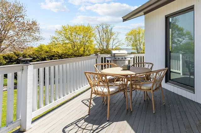 deck featuring outdoor dining space and a grill