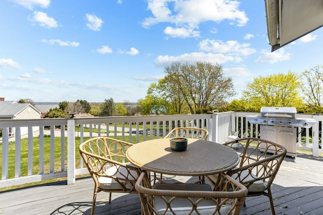 wooden terrace with grilling area, a yard, and outdoor dining area