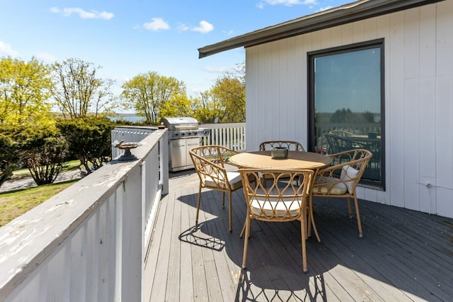wooden terrace featuring grilling area and outdoor dining area