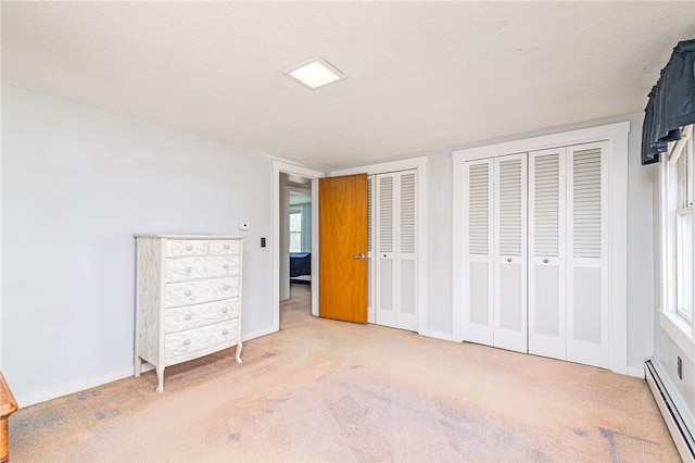 141 Canal St, Westerly, RI 02891 - unfurnished bedroom featuring multiple closets, baseboards, a baseboard heating unit, and light carpet