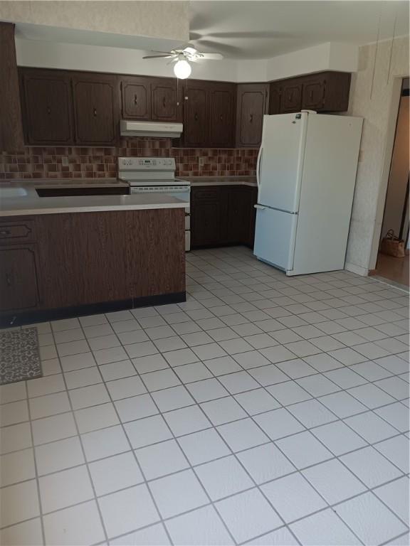 kitchen featuring tasteful backsplash, white appliances, under cabinet range hood, dark brown cabinets, and a ceiling fan