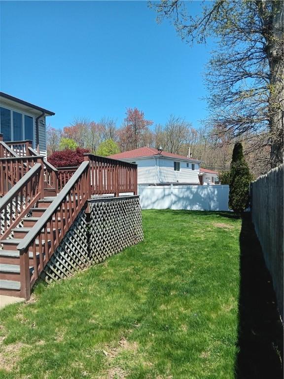 view of yard featuring fence, stairway, and a deck
