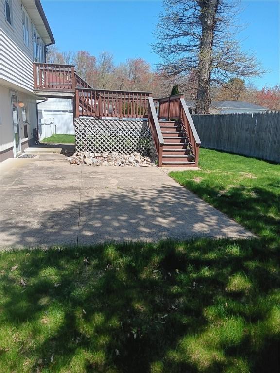 view of yard featuring a patio, stairs, a wooden deck, and fence