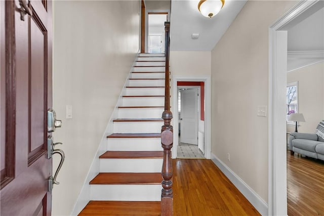 entryway with stairway, wood finished floors, and baseboards