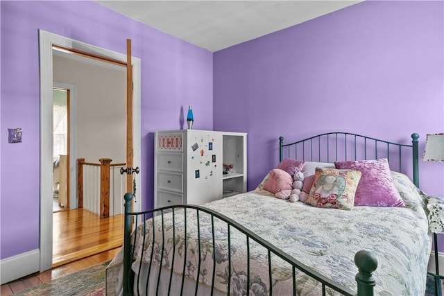 bedroom with wood finished floors and baseboards