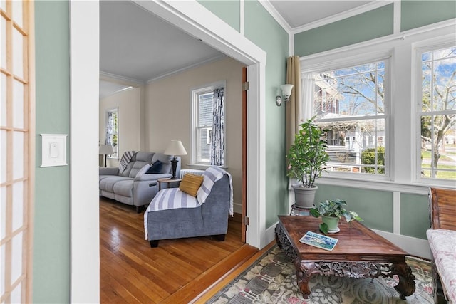 interior space with wood finished floors, crown molding, and baseboards