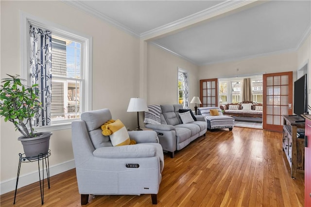 living area with baseboards, light wood-style floors, and crown molding