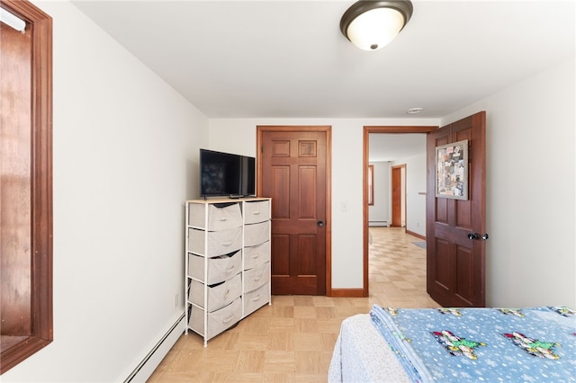bedroom featuring baseboards, light floors, and a baseboard radiator