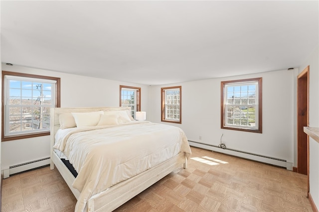 bedroom featuring a baseboard heating unit and multiple windows