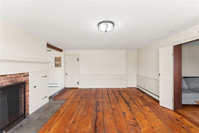 unfurnished living room with baseboard heating, hardwood / wood-style flooring, a baseboard heating unit, and a brick fireplace
