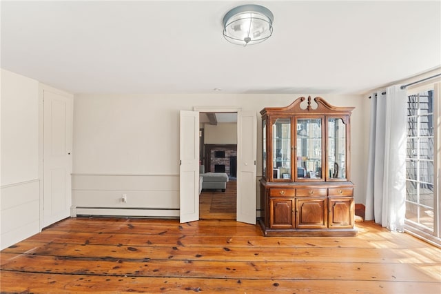 spare room with a baseboard heating unit and light wood-style floors