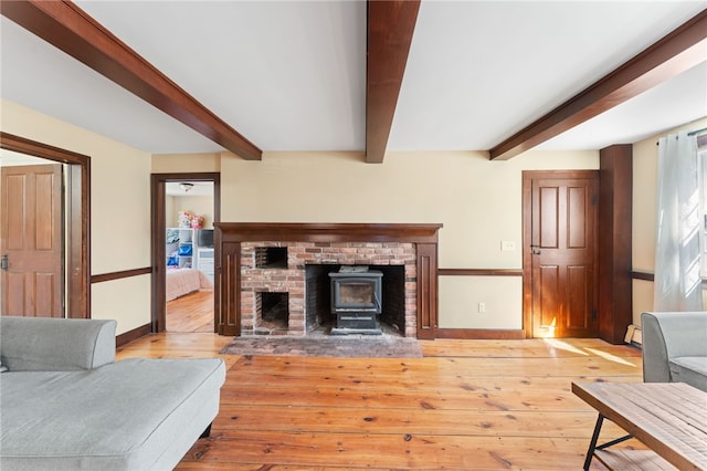 living area with beam ceiling, baseboards, and wood-type flooring