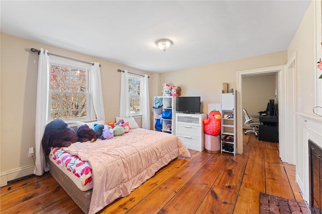 bedroom featuring a baseboard radiator and hardwood / wood-style floors
