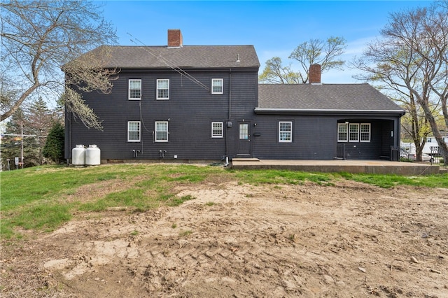 back of property featuring roof with shingles and a chimney