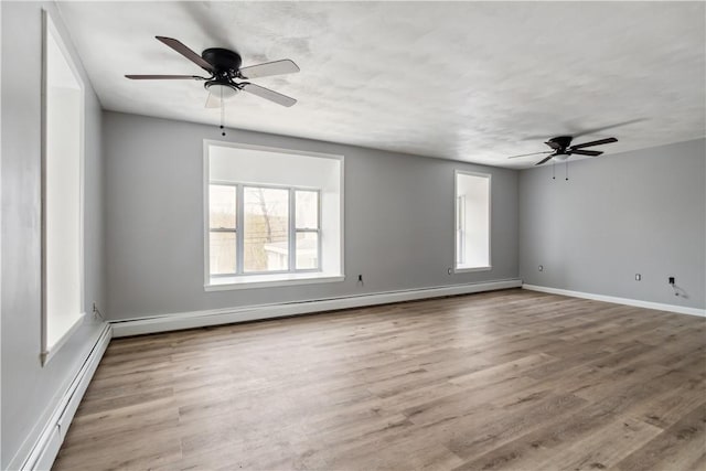 unfurnished room featuring a baseboard heating unit, a ceiling fan, and wood finished floors