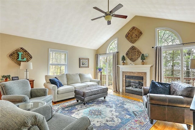 living room with a wealth of natural light, wood finished floors, and ceiling fan