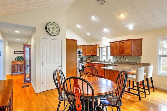 dining space with light wood finished floors, recessed lighting, visible vents, and baseboards