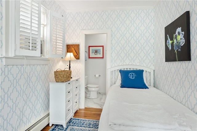 bedroom featuring crown molding, baseboard heating, wallpapered walls, and connected bathroom