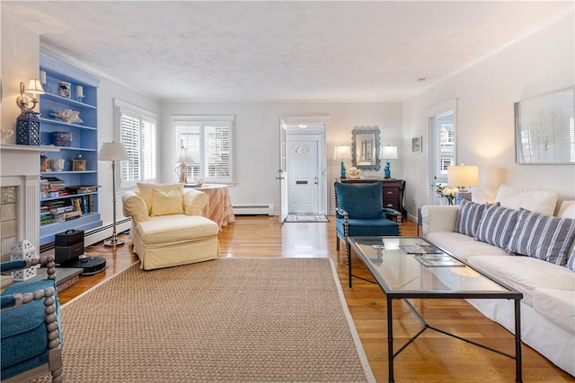 living room featuring wood finished floors, built in features, crown molding, and a baseboard radiator