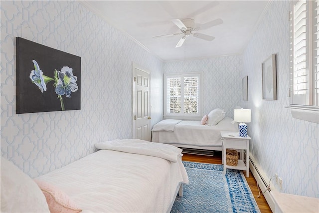 bedroom featuring wood finished floors, wallpapered walls, and multiple windows