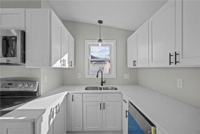 kitchen with a sink, white cabinets, appliances with stainless steel finishes, and lofted ceiling