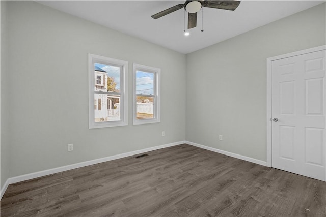 unfurnished bedroom featuring dark wood-style flooring, visible vents, ceiling fan, and baseboards