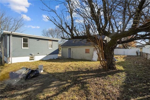 back of property featuring fence and a lawn