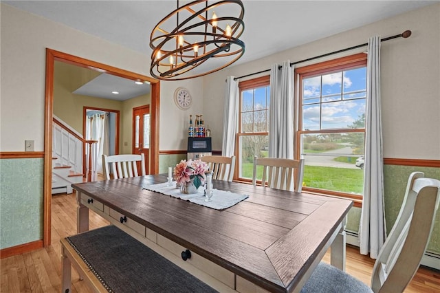 dining space featuring stairway, a chandelier, plenty of natural light, and light wood-style flooring