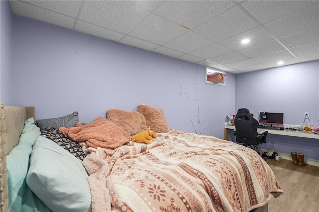 bedroom with recessed lighting, wood finished floors, and a drop ceiling