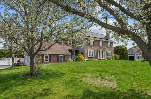 colonial inspired home featuring a front lawn and fence