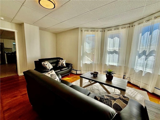 172 Park Ave, Woonsocket, RI 02895 - living room featuring a baseboard heating unit, a healthy amount of sunlight, a paneled ceiling, and wood finished floors