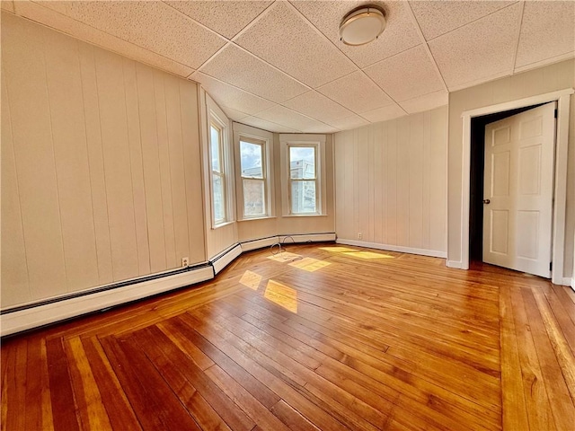 172 Park Ave, Woonsocket, RI 02895 - spare room with baseboards, a drop ceiling, and light wood-style flooring