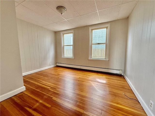 172 Park Ave, Woonsocket, RI 02895 - spare room with wood-type flooring, baseboards, a baseboard heating unit, and wooden walls
