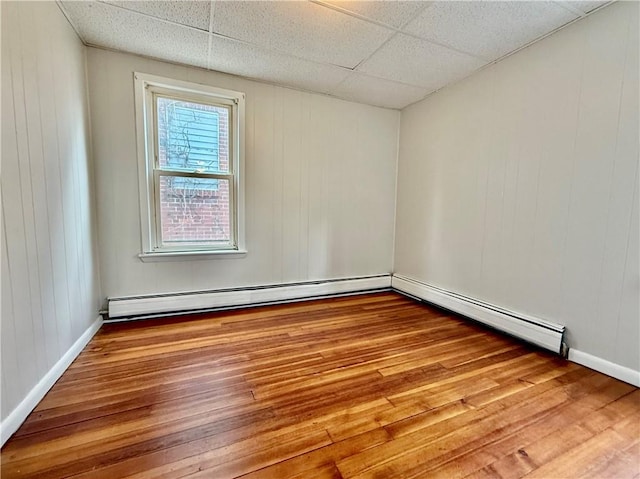 172 Park Ave, Woonsocket, RI 02895 - empty room featuring baseboards, a baseboard radiator, a drop ceiling, and wood finished floors