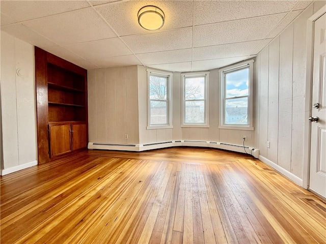 172 Park Ave, Woonsocket, RI 02895 - unfurnished living room with a healthy amount of sunlight, built in features, baseboard heating, and light wood-style flooring