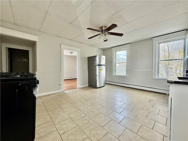 172 Park Ave, Woonsocket, RI 02895 - interior space featuring a drop ceiling, light tile patterned floors, a baseboard heating unit, and ceiling fan