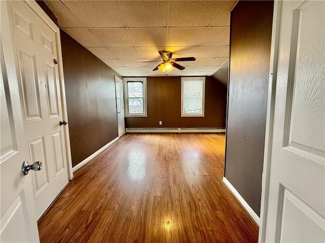 172 Park Ave, Woonsocket, RI 02895 - spare room with ceiling fan, baseboard heating, wood finished floors, baseboards, and a drop ceiling