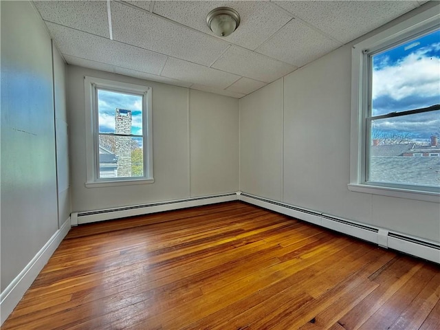 172 Park Ave, Woonsocket, RI 02895 - unfurnished room with a drop ceiling, baseboard heating, and hardwood / wood-style floors