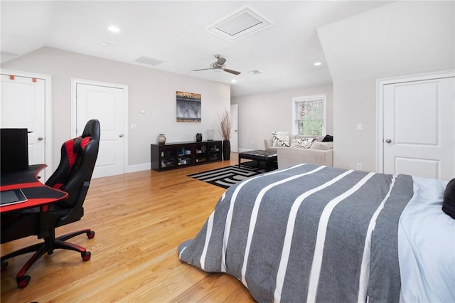 bedroom with attic access, ceiling fan, visible vents, baseboards, and wood finished floors