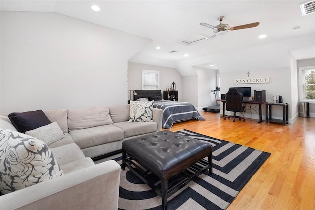 living room featuring attic access, recessed lighting, visible vents, light wood-style flooring, and vaulted ceiling