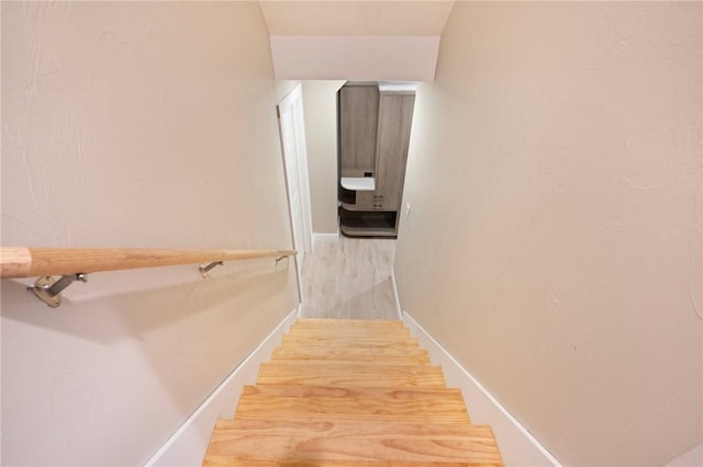 stairs featuring wood finished floors and baseboards