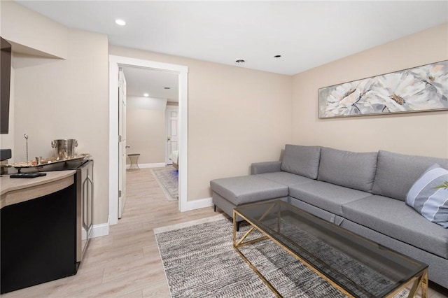 living area featuring recessed lighting, light wood-style flooring, and baseboards