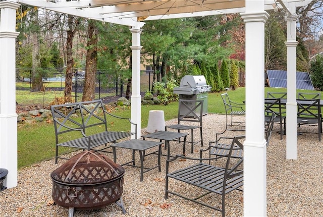 view of patio / terrace featuring an outdoor fire pit, fence, area for grilling, and a pergola