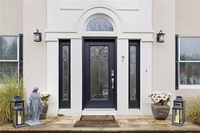entrance to property featuring stucco siding
