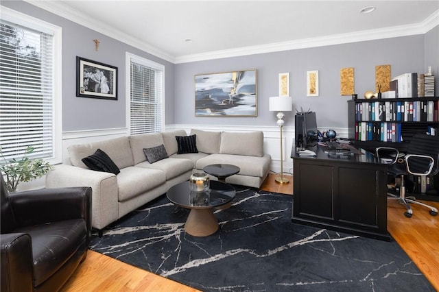 living room featuring wood finished floors, crown molding, and a wainscoted wall