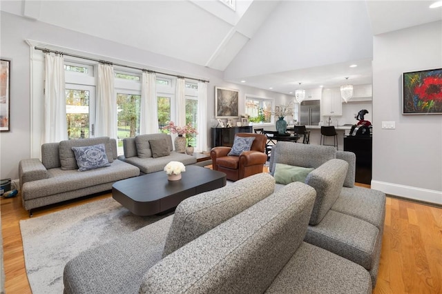 living area with baseboards, recessed lighting, light wood-style floors, and high vaulted ceiling