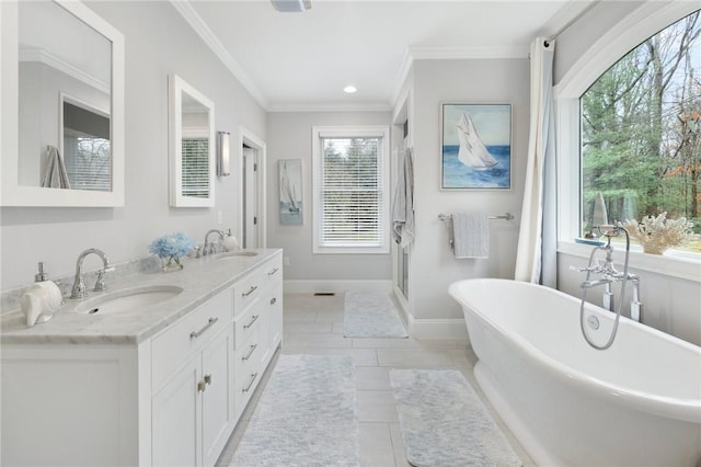 full bath with ornamental molding, a sink, a shower stall, and a soaking tub